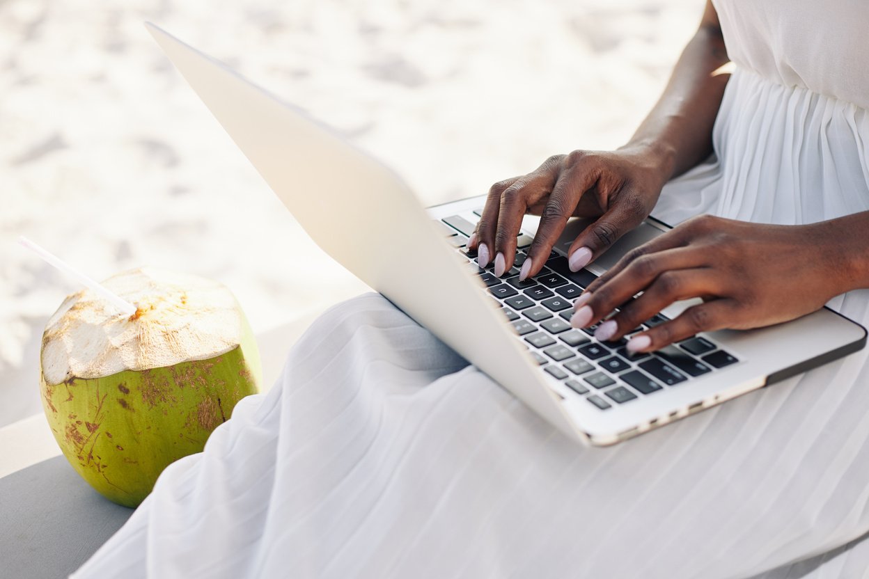 Woman Working on Laptop on Beach