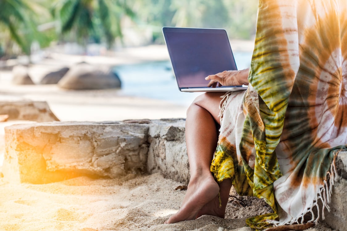 Woman at beach working on laptop